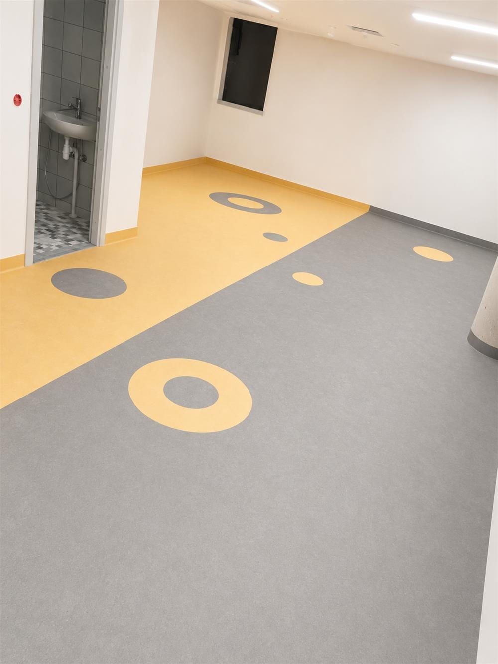 Circle-pattern sheet vinyl flooring installed in a commercial corridor